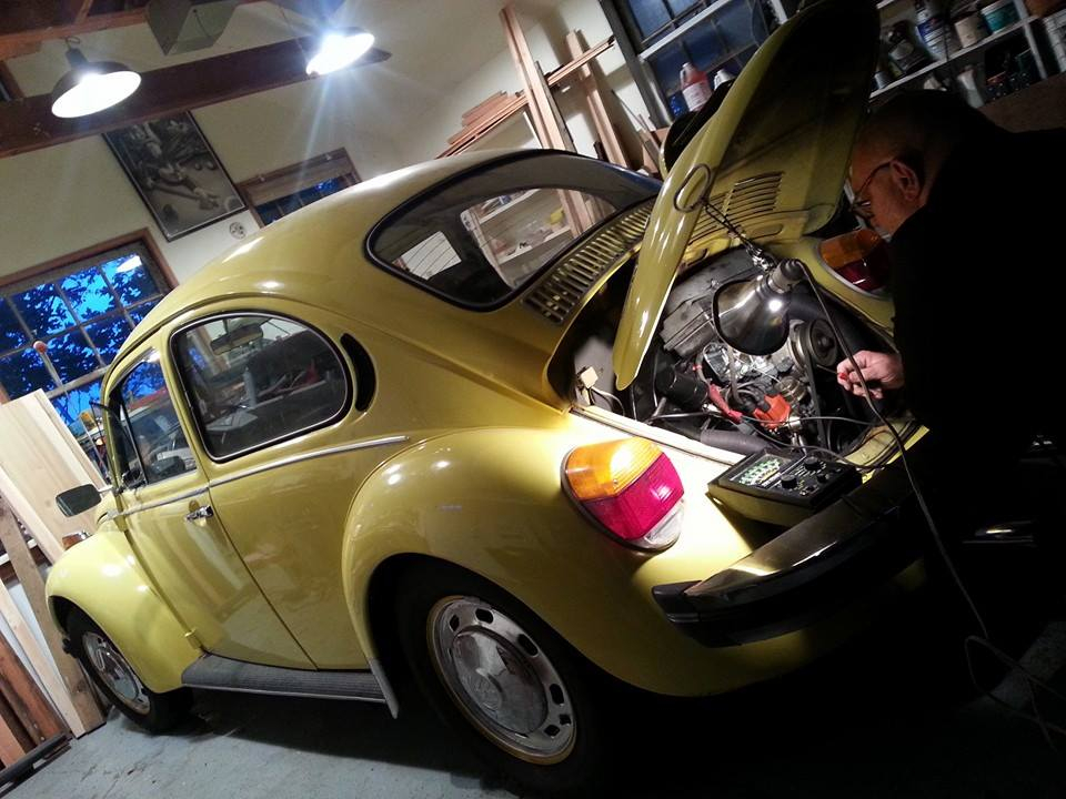 Technician working on classic Volkswagen Beetle